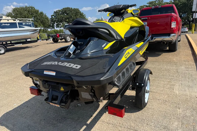 Slide: The Image of 2016 Sea-Doo GTR 215 jet ski on trailer, parked near red truck. - 48