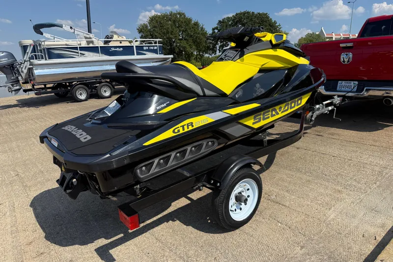Slide: The Image of 2016 Sea-Doo GTR 215 jet ski on trailer, parked outdoors. - 49
