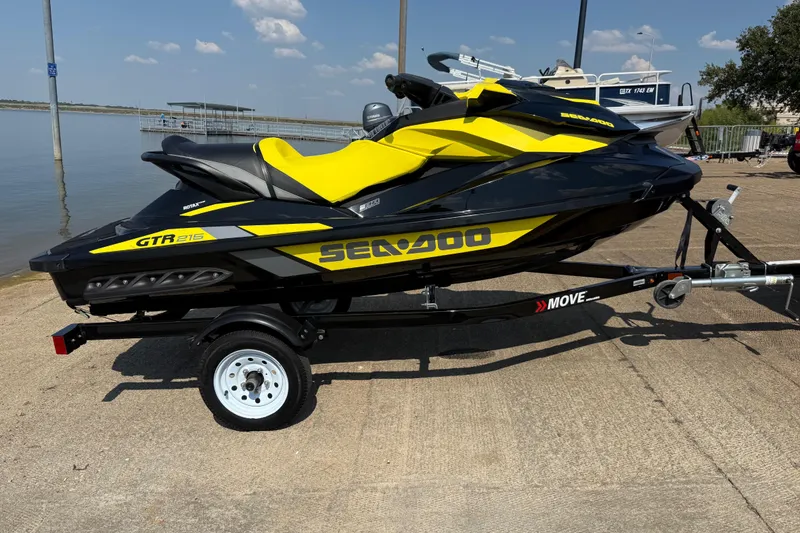 Slide: The Image of 2016 Sea-Doo GTR 215 jet ski on trailer by a lake under a clear sky. - 51