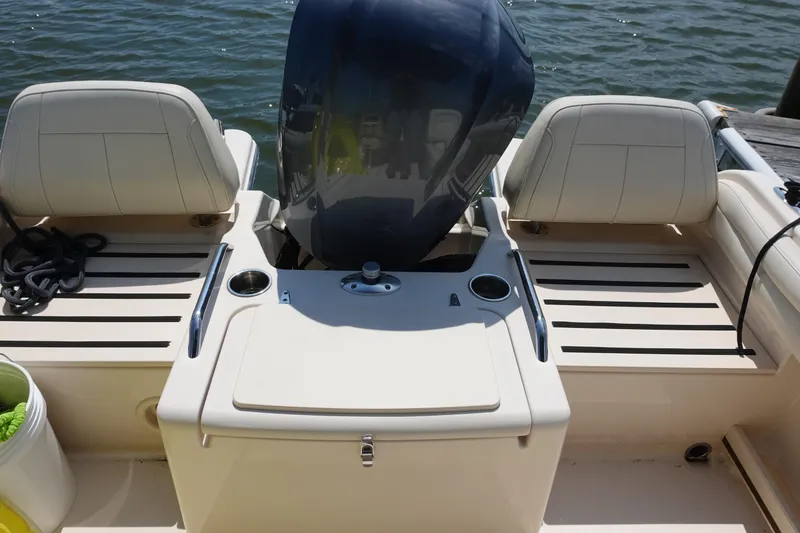 Slide: The Image of 2020 Grady-White Freedom 215 boat interior with seating and engine, docked by the water. - 15