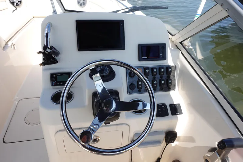 Slide: The Image of 2020 Grady-White Freedom 215 boat dashboard with steering wheel and control panel. - 6