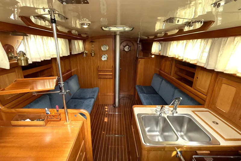 Slide: The Image of Interior of a 1987 Bristol 35.5 yacht with wood paneling and blue seating. - 14