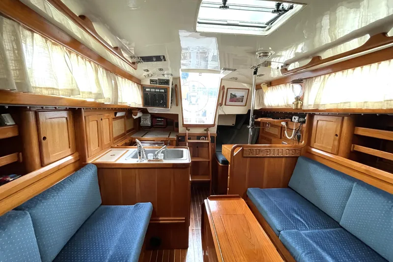 Slide: The Image of Interior of a 1987 Bristol 35.5 sailboat with wood cabinetry and blue seating. - 16