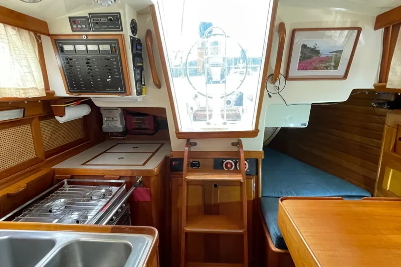 Slide: The Image of 1987 Bristol 35.5 yacht interior with kitchen, control panel, and cozy sleeping area. - 17
