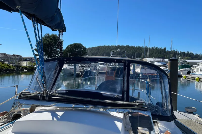 Slide: The Image of 1987 Bristol 35.5 sailboat docked in a serene marina under clear blue skies. - 5
