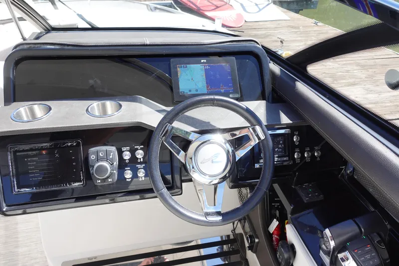 Slide: The Image of 2018 Sea Ray SLX 310 Outboard dashboard with steering wheel and navigation display. - 10