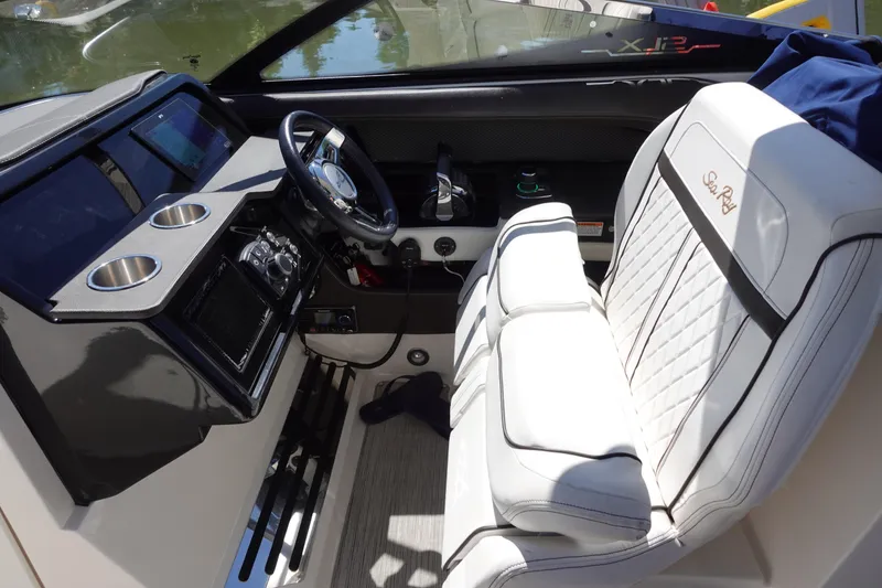 Slide: The Image of 2018 Sea Ray SLX 310 Outboard cockpit with white seating and modern dashboard controls. - 11