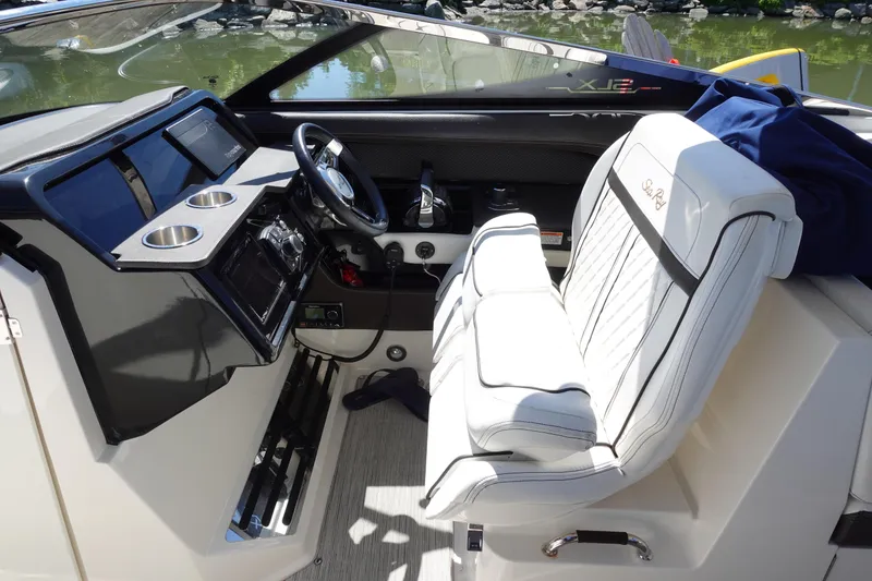 Slide: The Image of 2018 Sea Ray SLX 310 Outboard cockpit with white seating and modern dashboard controls. - 13