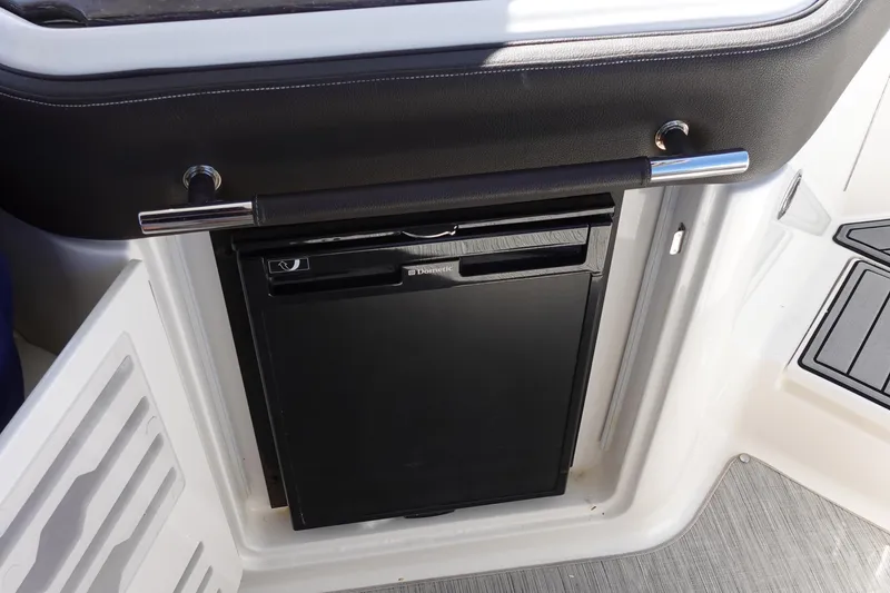 Slide: The Image of 2018 Sea Ray SLX 310 Outboard interior with built-in Dometic refrigerator. - 24