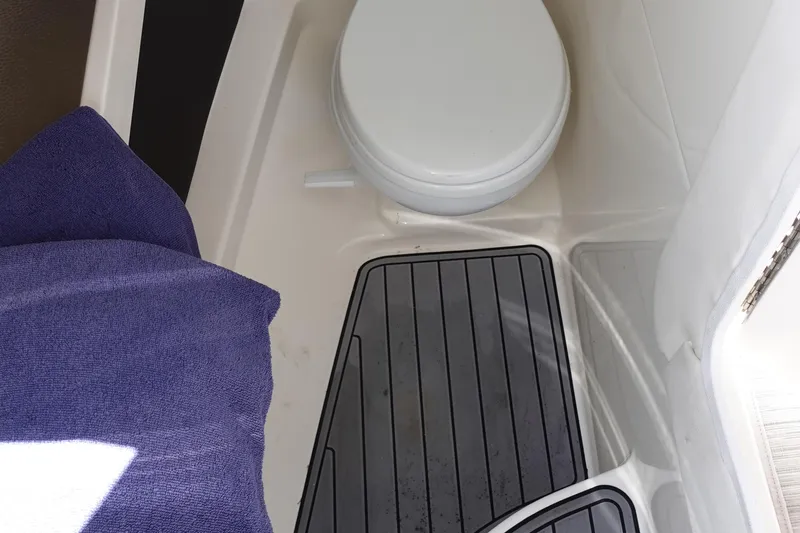 Slide: The Image of 2018 Sea Ray SLX 310 Outboard boat bathroom with toilet and floor mat. - 29