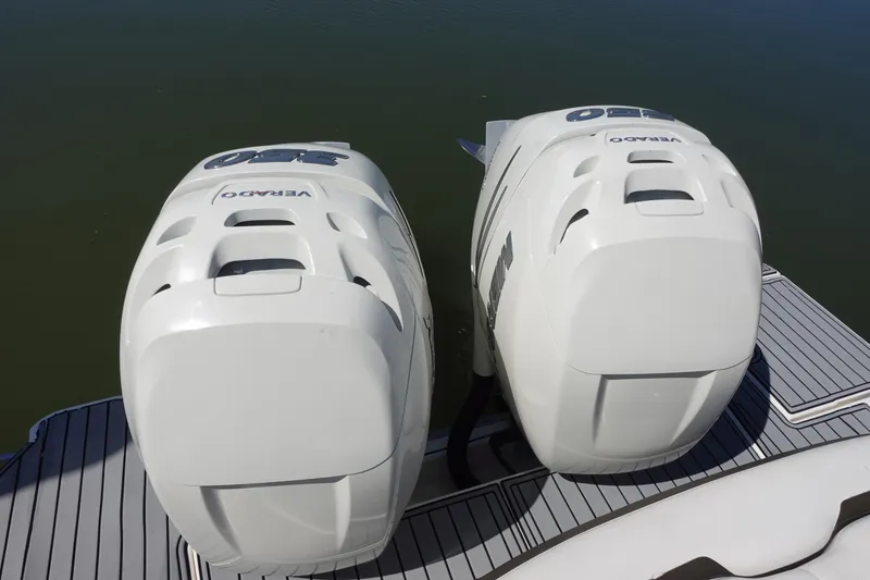 Slide: The Image of Twin outboard engines on a 2018 Sea Ray SLX 310 boat, docked on calm water. - 8