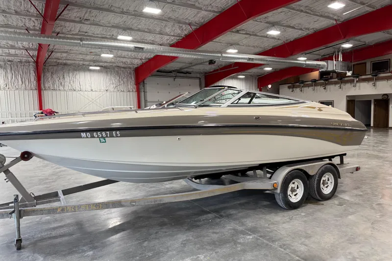 Slide: The Image of 2000 Crownline 225 BR boat on trailer in indoor storage facility. - 1
