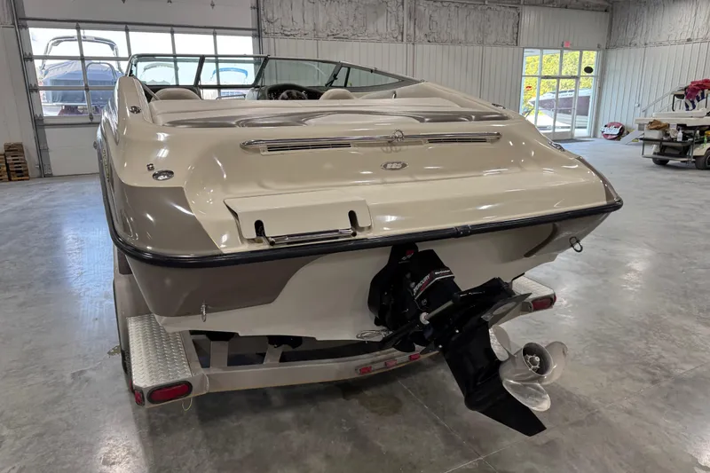 Slide: The Image of 2000 Crownline 225 BR boat in a garage, rear view showing propeller and trailer. - 12