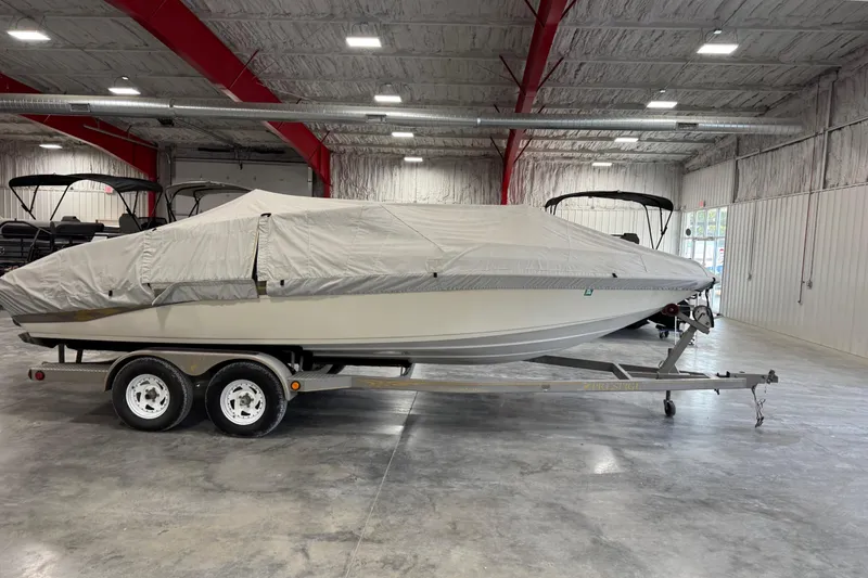Slide: The Image of 2000 Crownline 225 BR boat covered on trailer in indoor storage facility. - 17