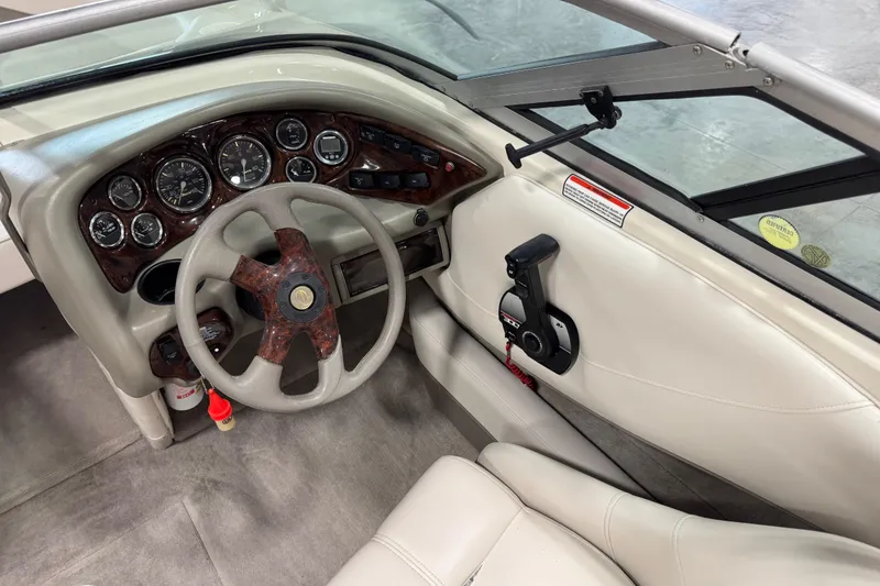 Slide: The Image of 2000 Crownline 225 BR boat interior with steering wheel and dashboard controls. - 9