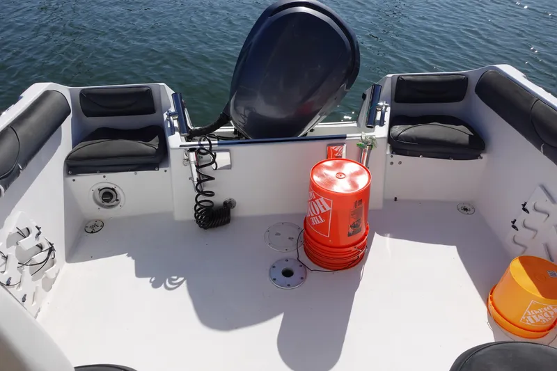 Slide: The Image of 2004 Prosports 2250 boat interior with seating, orange buckets, and water view. - 13