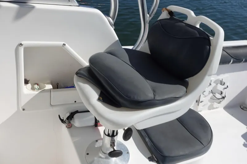 Slide: The Image of Boat seat on a 2004 Prosports 2250, featuring black cushions and white frame. - 16