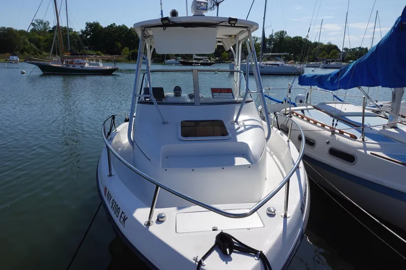 Slide: The Image of 2004 PROSPORT 2250 boat docked in a marina, surrounded by sailboats. - 2