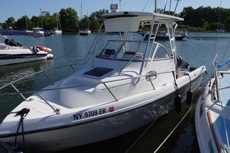 Slide: The Image of 2004 PROSPORT 2250 boat docked in a marina, surrounded by other vessels. - 3
