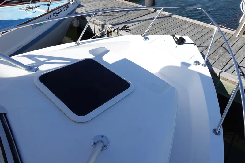 Slide: The Image of Bow of 2004 Prosports 2250 boat docked at marina, featuring a hatch and railing. - 4