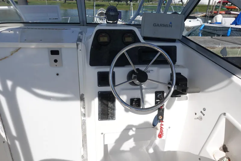 Slide: The Image of 2004 Prosports 2250 boat helm with steering wheel and Garmin navigation system. - 7