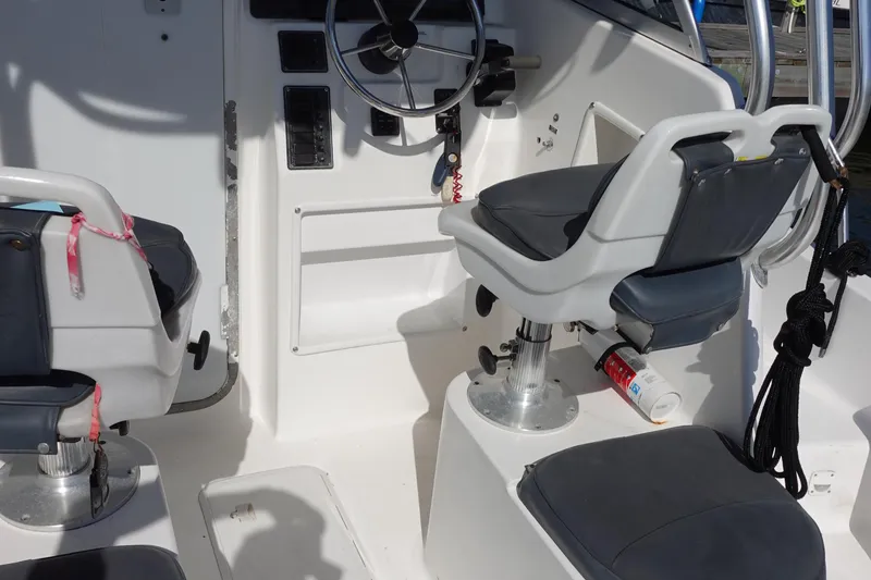 Slide: The Image of Interior of a 2004 Prosports 2250 boat with steering wheel and seating. - 8