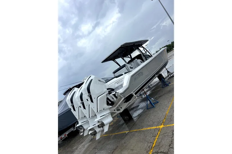 Slide: The Image of 2023 Nor-Tech 390 Sport Center Console boat with triple outboard engines on display. - 5