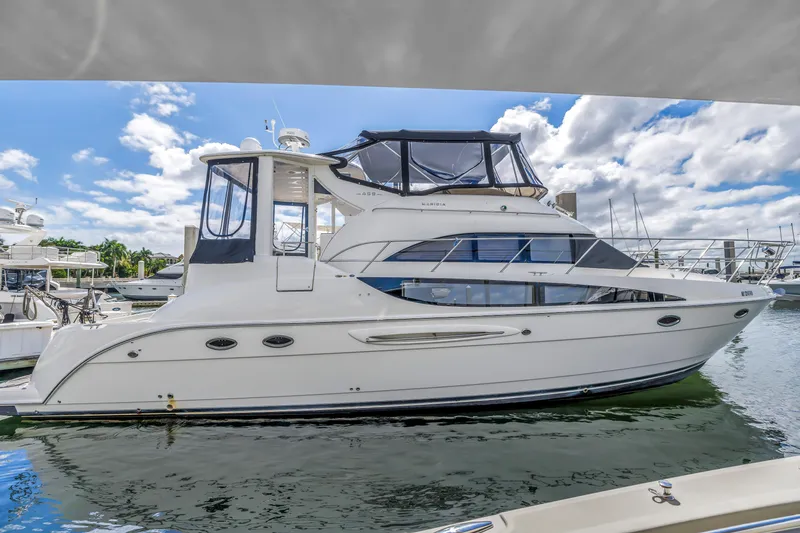 Slide: The Image of 2008 Meridian 459 Motoryacht docked in a marina under a partly cloudy sky. - 0