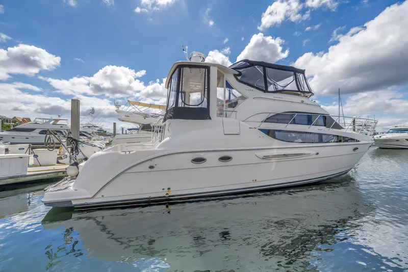 Slide: The Image of 2008 Meridian 459 Motoryacht docked under a bright blue sky with clouds. - 1