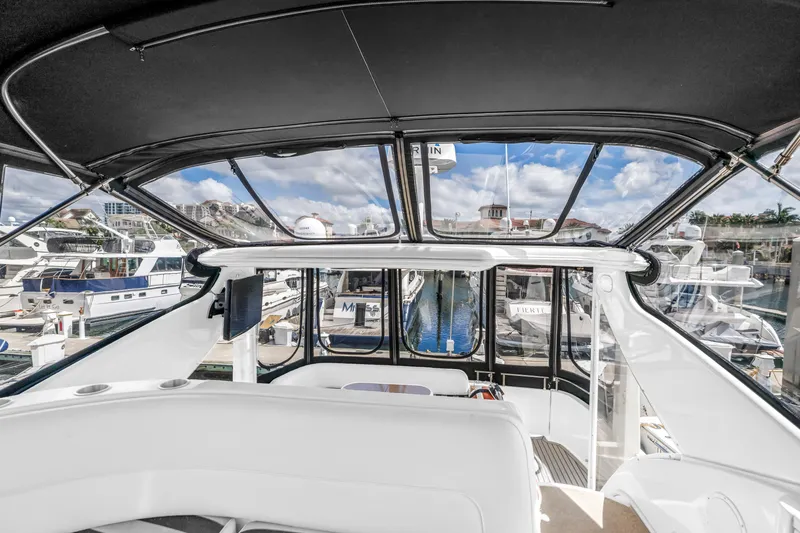 Slide: The Image of 2008 Meridian 459 Motoryacht interior view at marina, showcasing helm and surrounding boats. - 11