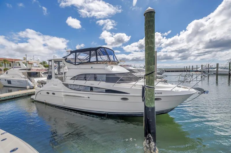 Slide: The Image of 2008 Meridian 459 Motoryacht docked in a sunny marina, under a partly cloudy sky. - 2
