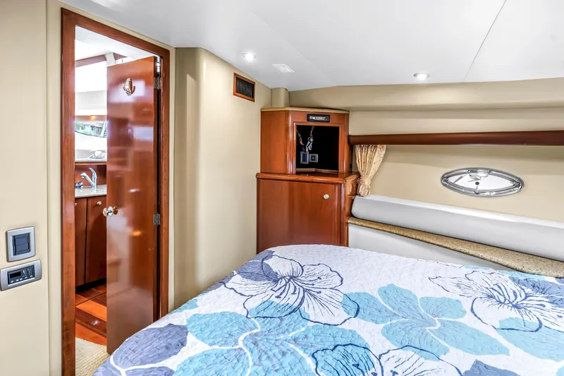 Slide: The Image of Interior of 2007 Meridian 459 Motoryacht bedroom with floral bedding and wooden cabinetry. - 31