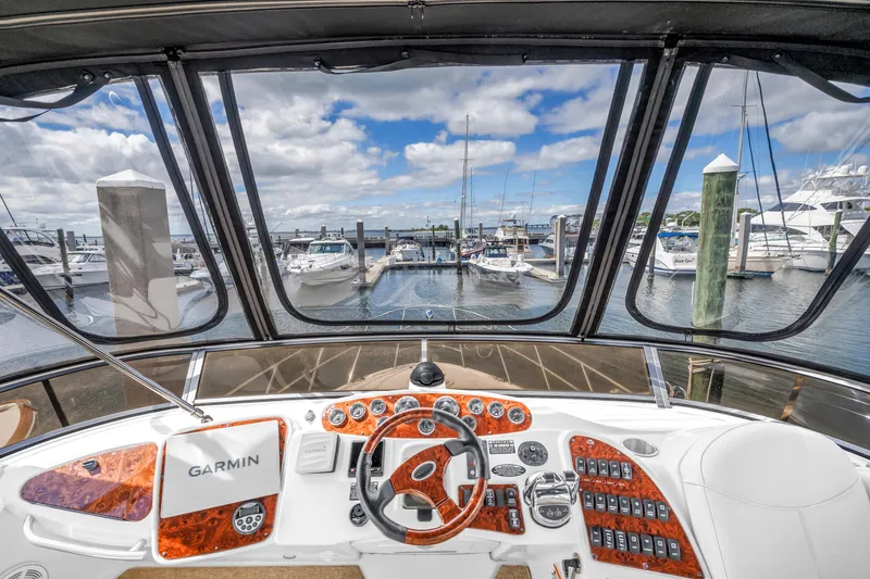 Slide: The Image of 2008 Meridian 459 Motoryacht helm with Garmin navigation, overlooking marina with docked boats. - 9