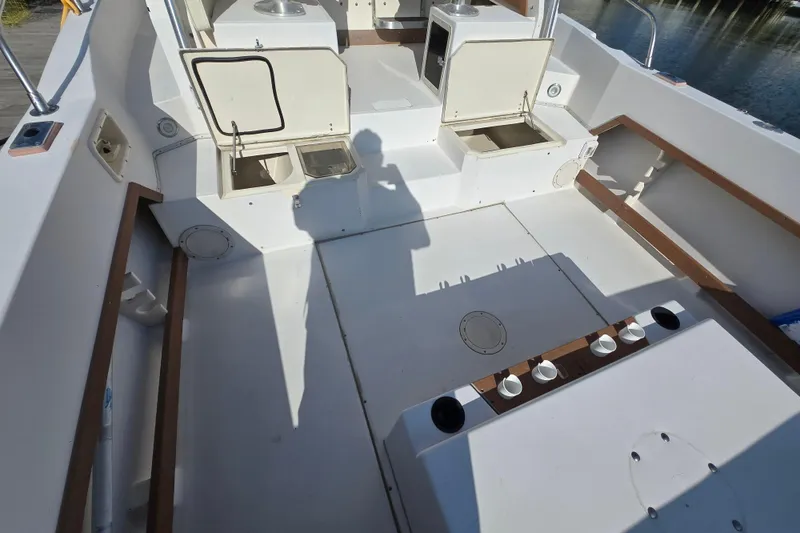 Slide: The Image of 1992 Grady-White Sailfish 25 Sportbridge boat deck with open storage compartments. - 17