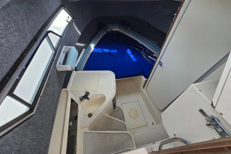 Slide: The Image of 1992 Grady-White Sailfish 25 Sportbridge cabin interior with sink and seating area. - 2