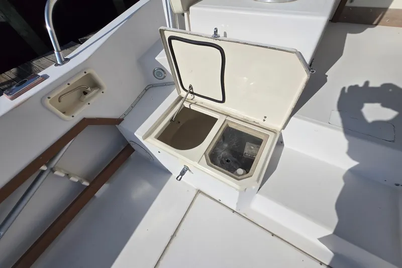 Slide: The Image of 1992 Grady-White Sailfish 25 Sportbridge boat compartment with open hatch and storage area. - 21