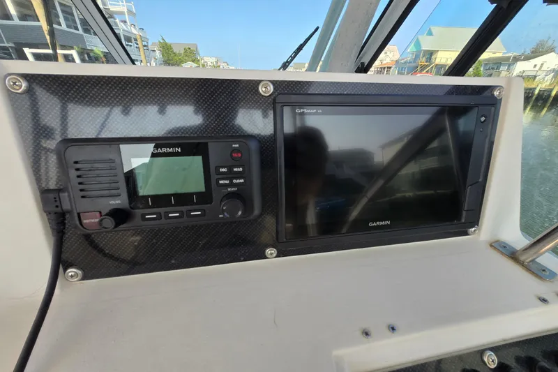 Slide: The Image of 1992 Grady-White Sailfish 25 Sportbridge dashboard with Garmin GPS and radio equipment. - 22