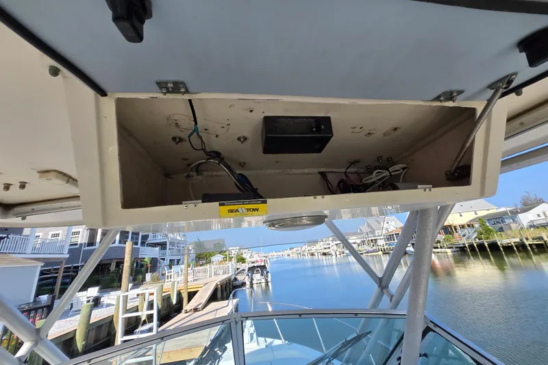 Slide: The Image of 1992 Grady-White Sailfish 25 Sportbridge boat interior with open storage compartment, dockside view. - 27