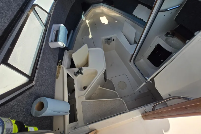 Slide: The Image of 1992 Grady-White Sailfish 25 Sportbridge cabin interior with sink and seating area. - 28