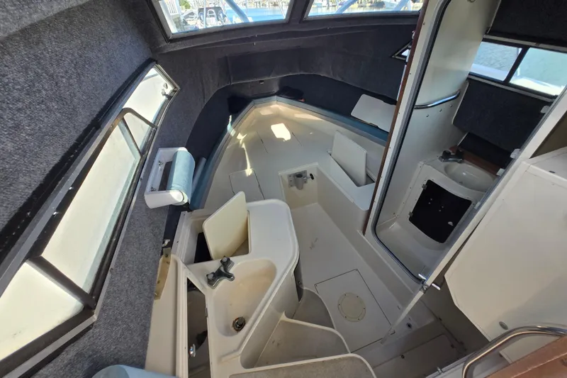 Slide: The Image of 1992 Grady-White Sailfish 25 Sportbridge cabin interior with sink and seating area. - 29