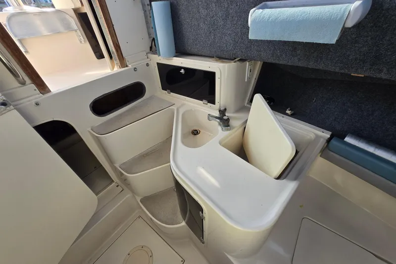 Slide: The Image of 1992 Grady-White Sailfish 25 Sportbridge cabin interior with sink and storage compartments. - 32