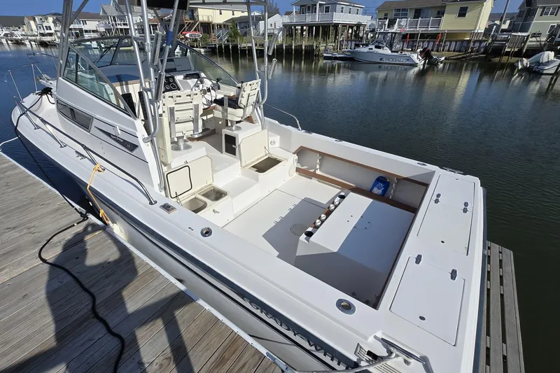 Slide: The Image of 1992 Grady-White Sailfish 25 Sportbridge docked, showcasing spacious deck and seating area. - 4
