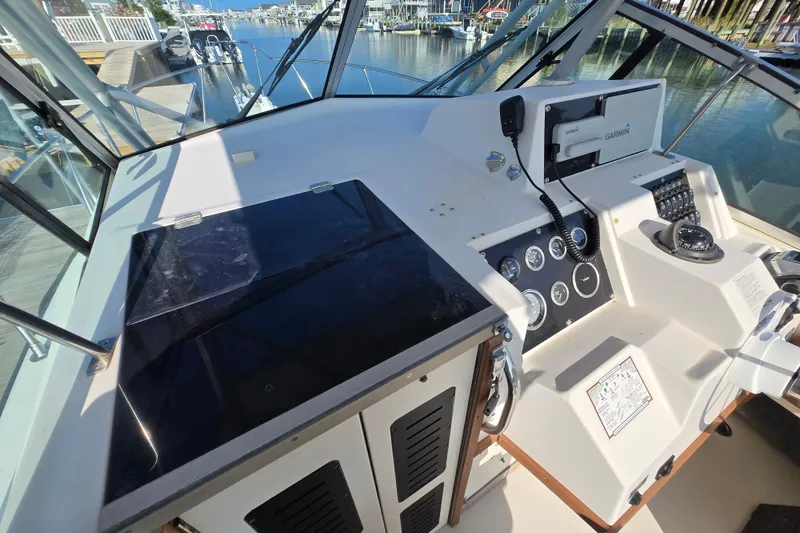 Slide: The Image of 1992 Grady-White Sailfish 25 Sportbridge helm with navigation instruments and waterfront view. - 5