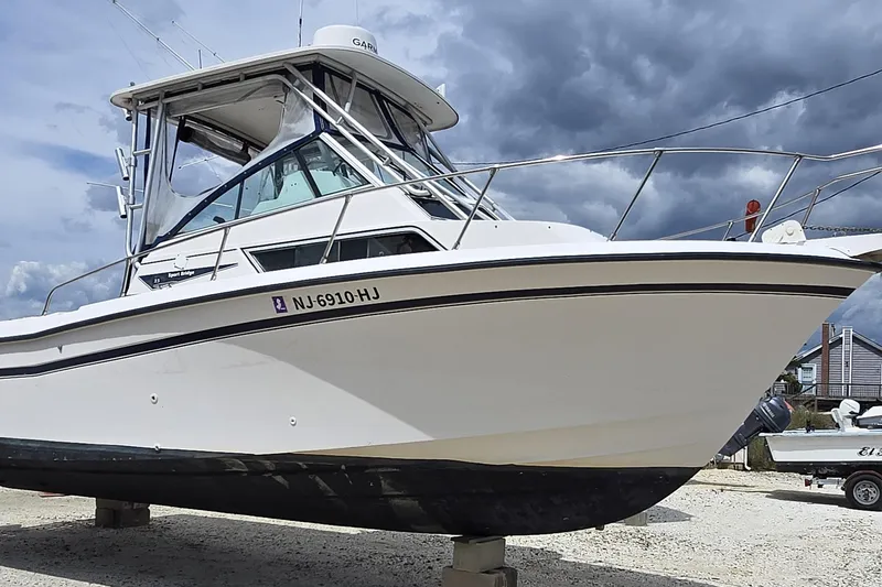 Slide: The Image of 1992 Grady-White Sailfish 25 Sportbridge boat on land under cloudy sky. - 7