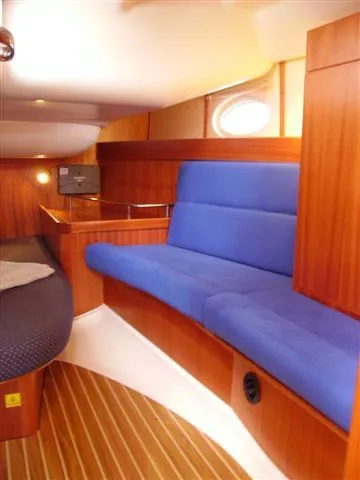 Slide: The Image of Interior of 2007 Elan Impression 434 yacht with blue seating and wooden paneling. - 11