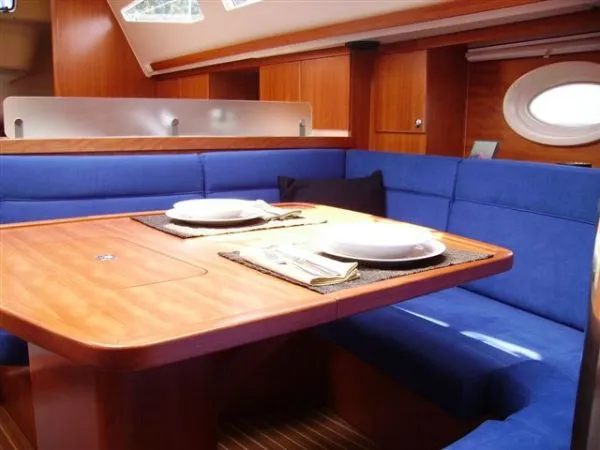 Slide: The Image of Interior of 2007 Elan Impression 434 yacht with blue seating and wooden table. - 2