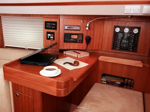 Slide: The Image of Navigation station in 2007 Elan Impression 434 yacht with laptop, coffee, and control panels. - 9