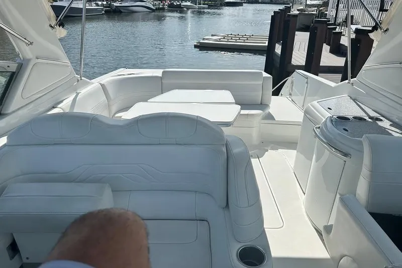 Slide: The Image of 2004 Formula 330 Sun Sport boat interior with white seating and waterfront view. - 14