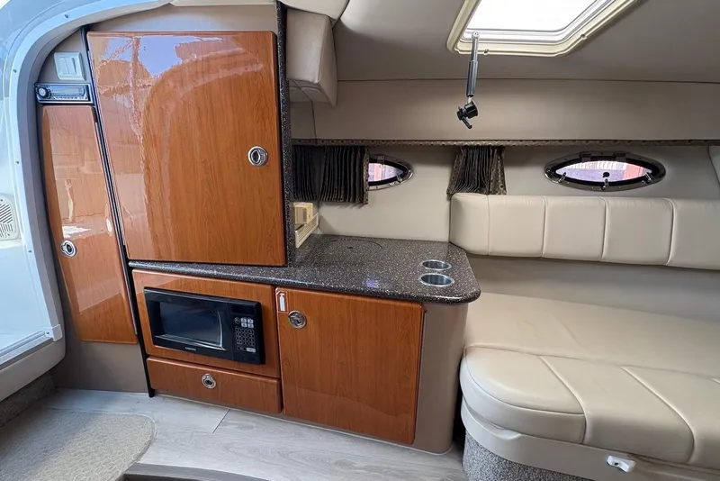 Slide: The Image of 2004 Formula 330 Sun Sport interior with kitchenette, microwave, and seating area. - 17