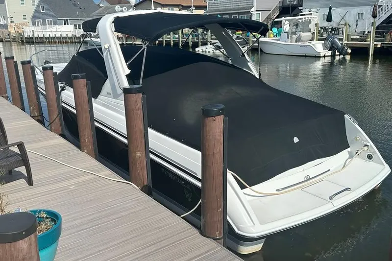 Slide: The Image of 2004 Formula 330 Sun Sport boat docked, covered with black canvas, in a marina setting. - 25
